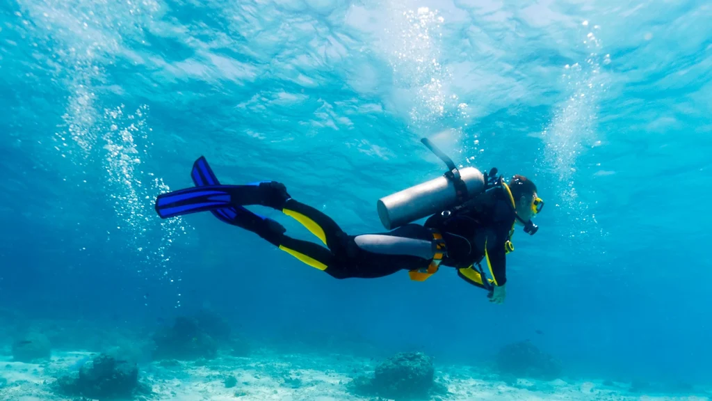 How to Improve Buoyancy Control for Better Diving in Hurghada Buoyancy control diving is one of the most important skills every scuba diver can develop. Good buoyancy allows you to move smoothly through the water, conserve energy, improve air consumption, and protect fragile coral reefs. Hurghada provides an excellent environment for practicing this skill. The clear Red Sea water makes it easier to observe your position and movement underwater. In addition, the area's colorful reefs give divers a strong reason to develop better control and avoid unnecessary contact with the seabed. Whether you are a beginner or an experienced diver, improving buoyancy can make every dive more comfortable. What Is Buoyancy Control? Buoyancy control means managing your position in the water so that you can remain stable without constantly kicking or changing depth. A well-balanced diver can: Hover comfortably Move efficiently Control depth Reduce unnecessary effort Protect the reef Improve air consumption Good buoyancy does not happen instantly. Instead, it develops through practice and better awareness of your equipment, breathing, and body position. Why Buoyancy Matters in Hurghada The Red Sea contains beautiful coral formations that can take many years to develop. Even a small accidental contact with a fin or tank can damage delicate marine life. Better buoyancy helps you remain above the reef while exploring. It also allows you to: Observe marine life without disturbing it Take underwater photographs more easily Swim through narrow areas safely Avoid stirring up sand Reduce physical effort Therefore, buoyancy is both a diving skill and an important environmental responsibility. Start With the Correct Weight One of the most common buoyancy problems comes from using too much weight. Extra weight forces you to add more air to your BCD, which can make your position less stable. Before diving, work with your instructor or guide to determine a suitable weight. A proper weighting setup should allow you to: Float comfortably at the surface Descend without excessive effort Maintain neutral buoyancy during the dive Avoid carrying unnecessary weight Your ideal weight can change depending on your wetsuit, tank, equipment, and water conditions. Learn to Control Your Breathing Your breathing affects your buoyancy. When you inhale, your body becomes slightly more buoyant. When you exhale, it becomes slightly less buoyant. You can use this natural movement to make small depth adjustments. Try to: Breathe slowly Avoid holding your breath Maintain a steady rhythm Observe how your depth changes With practice, breathing becomes one of your most useful buoyancy tools. Use Your BCD Carefully Your BCD helps you make larger buoyancy adjustments. However, beginners sometimes add or release too much air at once. Instead, make small changes and wait for the result. Remember that air expands as you ascend and becomes more compressed as you descend. Therefore, your buoyancy can change during a dive even when you do not add or remove equipment. Small adjustments help you remain stable. Improve Your Body Position Your body position, or trim, also affects buoyancy. A horizontal position usually allows you to move more efficiently than a vertical posture. Try to keep: Your body streamlined Your knees slightly bent Your fins behind you Your equipment secured Your head in a comfortable position Good trim reduces drag and makes swimming easier. Stop Using Your Fins Constantly Some divers use their fins continuously without realizing it. This habit can make buoyancy problems worse. Once you achieve neutral buoyancy, try stopping your fin movement for a few seconds. If you remain at the same depth, your buoyancy is probably close to correct. If you rise or sink, make a small adjustment rather than immediately kicking harder. Practice Hovering Hovering is one of the best exercises for improving buoyancy control diving skills. Choose a safe training area and attempt to remain in one position without: Kicking Touching the bottom Holding onto the reef Making large BCD adjustments Start with short periods. Then gradually increase the time. As your control improves, you will feel more relaxed underwater. Avoid Touching the Coral Good buoyancy is especially important when diving over coral reefs. Divers should never use coral as a handhold or push away from the reef with their fins. Instead, maintain enough distance to move freely. This protects: Hard corals Soft corals Small reef organisms Marine habitats It also reduces the chance of damaging your equipment. Improve Your Air Consumption Better buoyancy can help reduce unnecessary air consumption. When you remain stable, you do not need to constantly kick or make large body movements. This can reduce physical effort during a dive. However, air consumption depends on several factors, including: Experience Breathing pattern Depth Fitness Equipment Water conditions Do not focus only on extending your dive. Safety and proper gas management should always come first. Buoyancy and Underwater Photography Photographers benefit greatly from good buoyancy. A stable position makes it easier to compose images without touching the reef. Before taking a photograph: Establish neutral buoyancy. Stop unnecessary movement. Position yourself carefully. Take the photograph. Move away without touching the reef. This approach protects the environment while also producing clearer images. Practice in Different Conditions Once your buoyancy improves in calm water, practice in different environments. Each location can present new challenges. You may eventually encounter: Gentle currents Deeper water Reef walls Sandy bottoms Different exposure protection Your weighting and trim can feel different in each situation. Therefore, continue adjusting your technique as your experience grows. Common Buoyancy Mistakes Several habits can make buoyancy more difficult. Avoid: Carrying excessive weight Holding your breath Inflating the BCD too much Making large corrections Kicking constantly Ignoring your body position Touching the reef for stability Instead, focus on small, controlled movements. How Beginners Can Improve Faster New divers should not expect perfect buoyancy after only a few dives. The skill develops gradually. Practice simple exercises under professional supervision. For example, try hovering, controlled ascents, and slow descents in an appropriate training area. Ask your instructor to observe your: Breathing Body position Weighting Fin movement BCD use Constructive feedback can help you identify problems much faster. Advanced Divers Can Refine Their Technique Experienced divers can continue improving even after hundreds of dives. Advanced buoyancy control can make difficult dives easier and more enjoyable. You can work on: Precise depth control Horizontal trim Minimal fin movement Photography stability Current management Efficient movement These skills are particularly useful for wreck diving, underwater photography, and deeper Red Sea sites. Become a More Efficient Diver Buoyancy control diving skills improve with patience and consistent practice. The goal is not simply to float without sinking. Instead, the goal is to move naturally and efficiently while remaining aware of your surroundings. Hurghada's clear waters and beautiful reefs provide excellent opportunities to develop these abilities. With correct weighting, controlled breathing, good trim, and careful BCD use, you can become more comfortable underwater and reduce your impact on the marine environment. Final Thoughts Improving buoyancy control diving skills can transform the way you experience the Red Sea. You will move more smoothly, use less effort, enjoy marine life more closely, and protect the reefs around you. The best results come from regular practice rather than trying to master everything at once. Take your time, listen to your instructor, and focus on small improvements during every dive. Good buoyancy is not just an advanced technique. It is one of the foundations of safe, enjoyable, and responsible scuba diving.